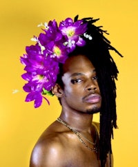 a man with dreadlocks and flowers on his head