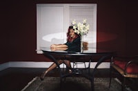 a woman sitting at a table with flowers