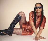 a woman in a dress and thigh high boots posing on the floor