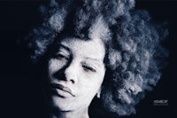 a woman with afro hair and a black background