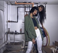 two women standing in a room with pipes