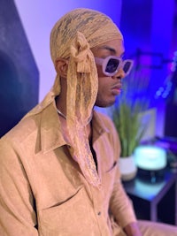 a man wearing sunglasses and a tan hat